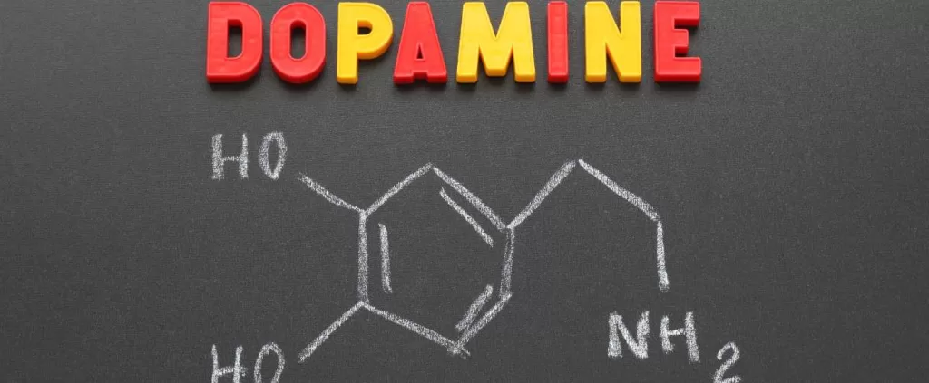 Ilustracja przedstawia kolorowy napis "dopamina" oraz jej wzór chemiczny C8H11NO2