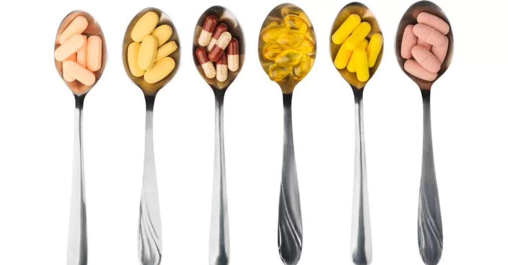 6 łyżeczek napełnionych suplementami diety, takimi jak omega 3, kurkumina, i adaptogeny